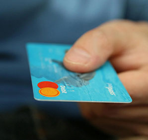 A person holding a credit card. Links to Gifts of Cash, Checks, and Credit Cards